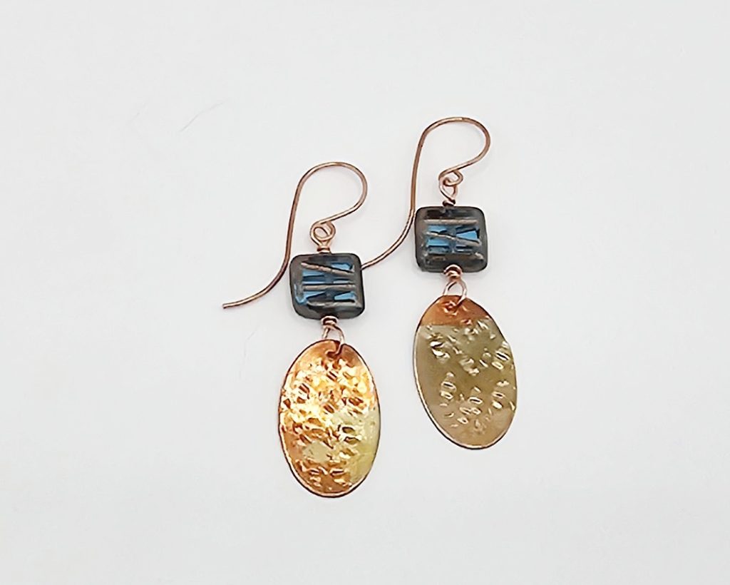 Handmade earrings with blue Czech glass square beads and flame-colored hammered copper dangles, 1.5 inches long.