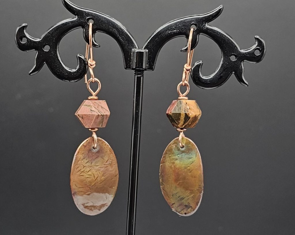 Handmade earrings with a copper oval dangle, hammered and flame colored, hung with diamond cut mookaite bead on copper earring wires