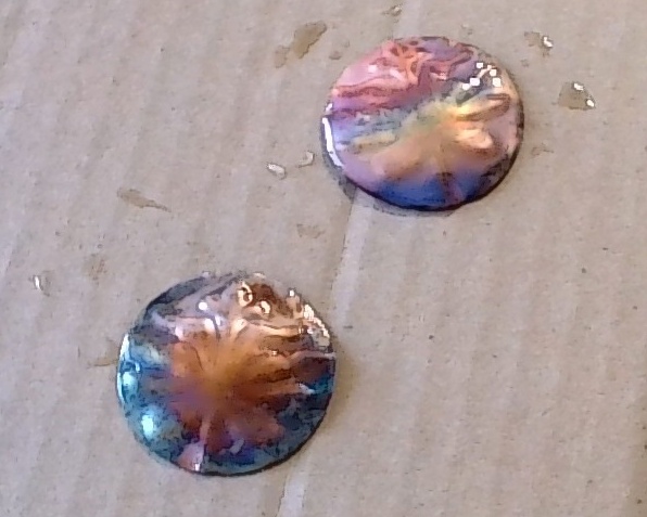 Flame colored copper discs before sealing, bright shades of blues, greens and pinks