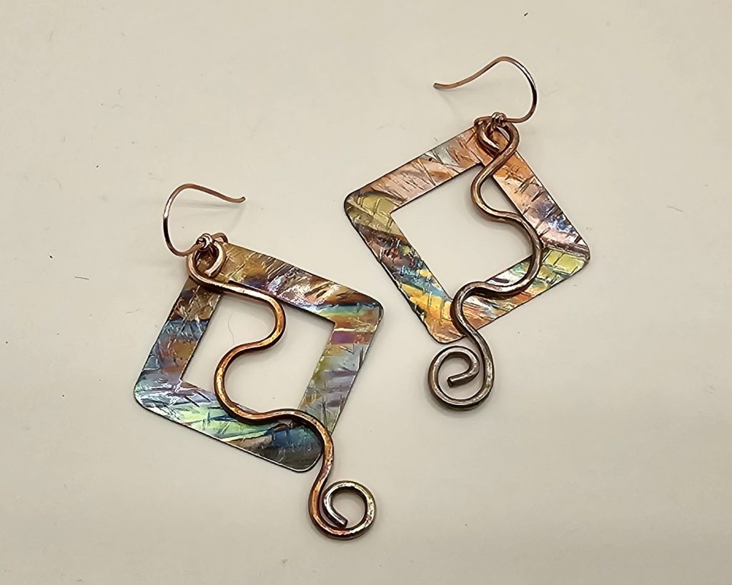 Handmade square shaped flame-colored copper earrings with swirl wire accents and handcrafted ear wires.