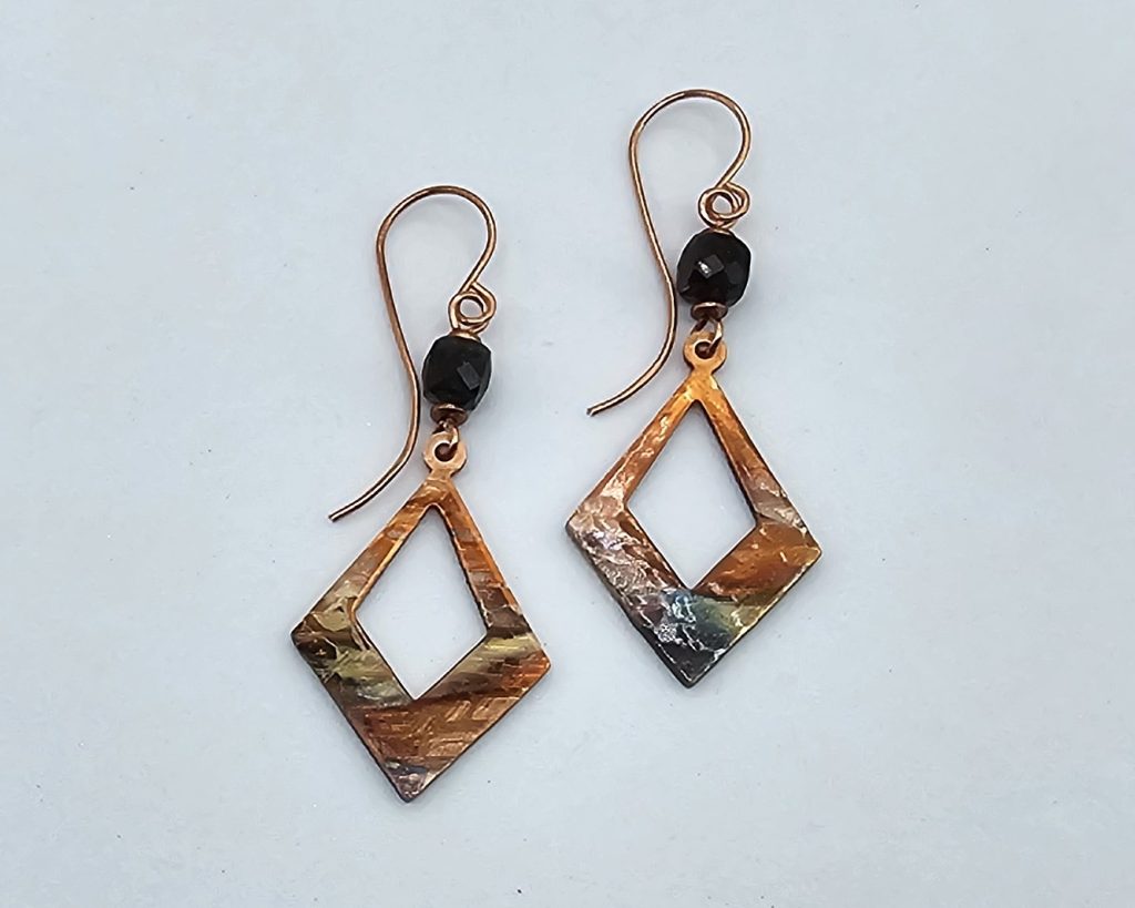 Handmade flame-colored copper earrings with diamond shaped copper dangles and tourmaline beads on handcrafted wires.