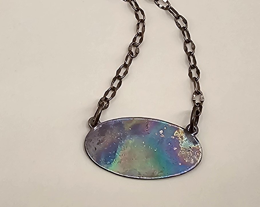 Copper necklace pendant flame colored to bring out iridescent rainbow hues of blues, purples, and greens