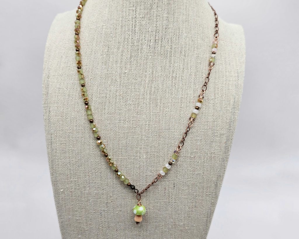Handmade lampwork mushroom necklace with pink and green faceted crystal beads on copper chain, 19.5 inch adjustable length.