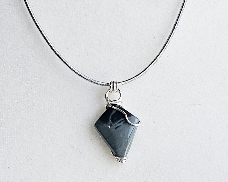 One-of-a-kind handmade wire wrapped dark stone pendant necklace with silver-tone detailing on an adjustable 20-inch chain.