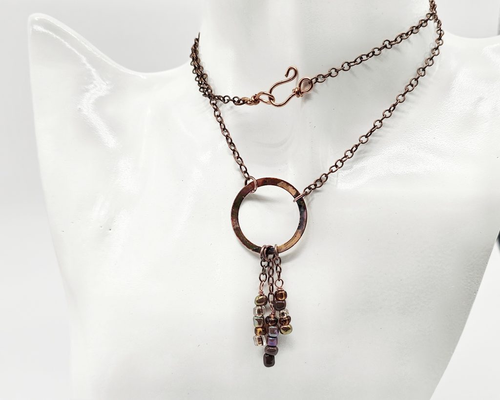 Handmade flame-colored copper circle necklace with glass seed bead dangles on a 20-inch copper chain with hook clasp.