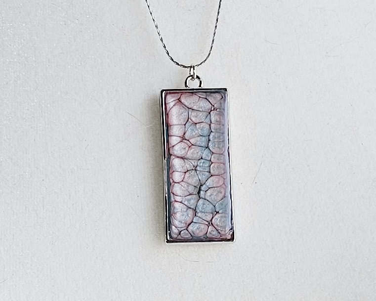 Handmade painted resin pendant necklace with pink and blue textured design on a silver-tone 20-inch snake chain.