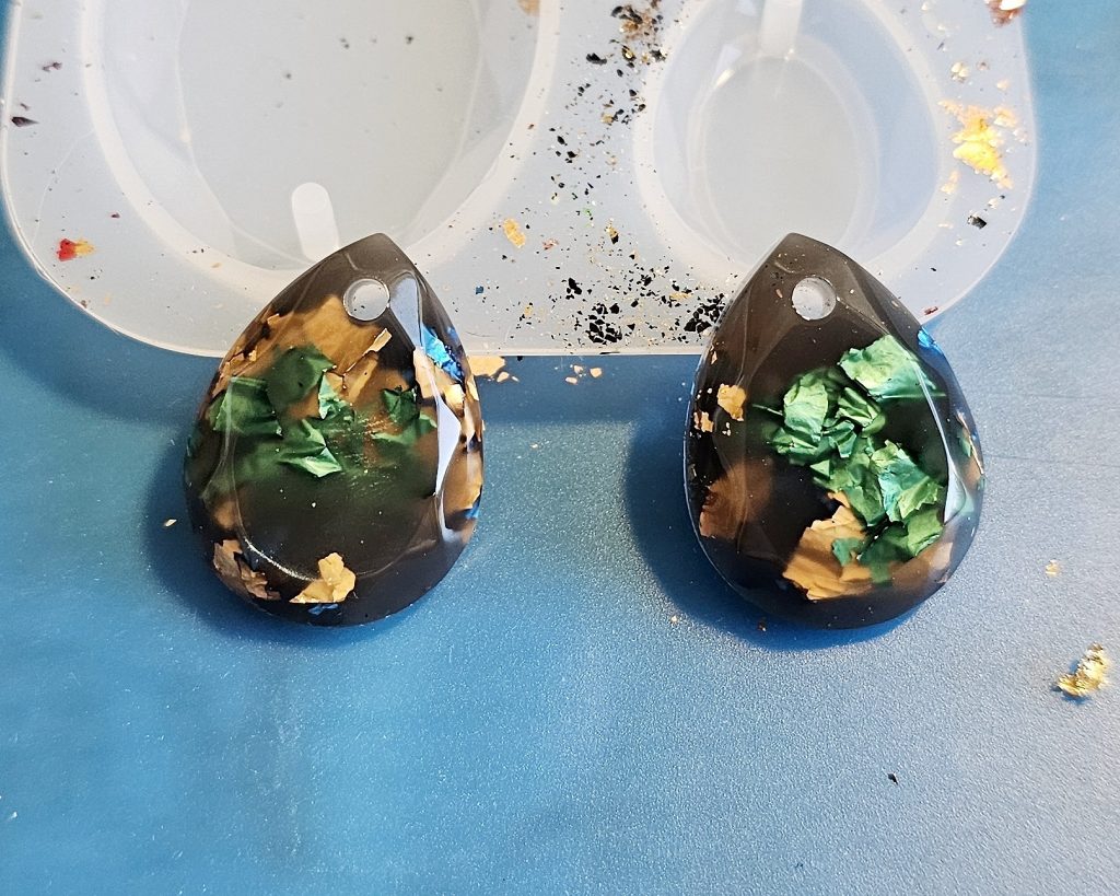 Teardrop shaped dangle made using UV resin and foil flakes in green, gold, blue, designed to mimic dichroic glass.